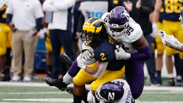 Michigan Wolverines running back Blake Corum (2) is tackled by Northwestern Wildcats linebacker Peter McIntyre (40) and defensive lineman Adetomiwa Adebawore (99) in the first half at Michigan Stadium. Rick Osentoski-USA TODAY Sports